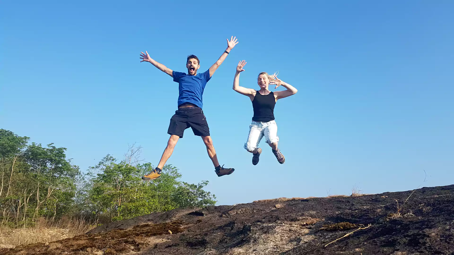 Guests enjoying a joyful trekking adventure near Sceva's Garden Home while exploring the scenic hills of Munnar.